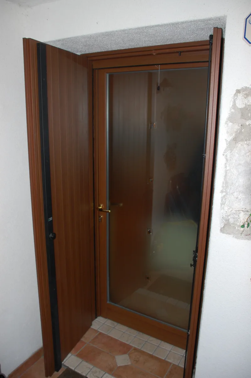 Portoncino di ingresso con scuro in effetto legno per casa in montagna